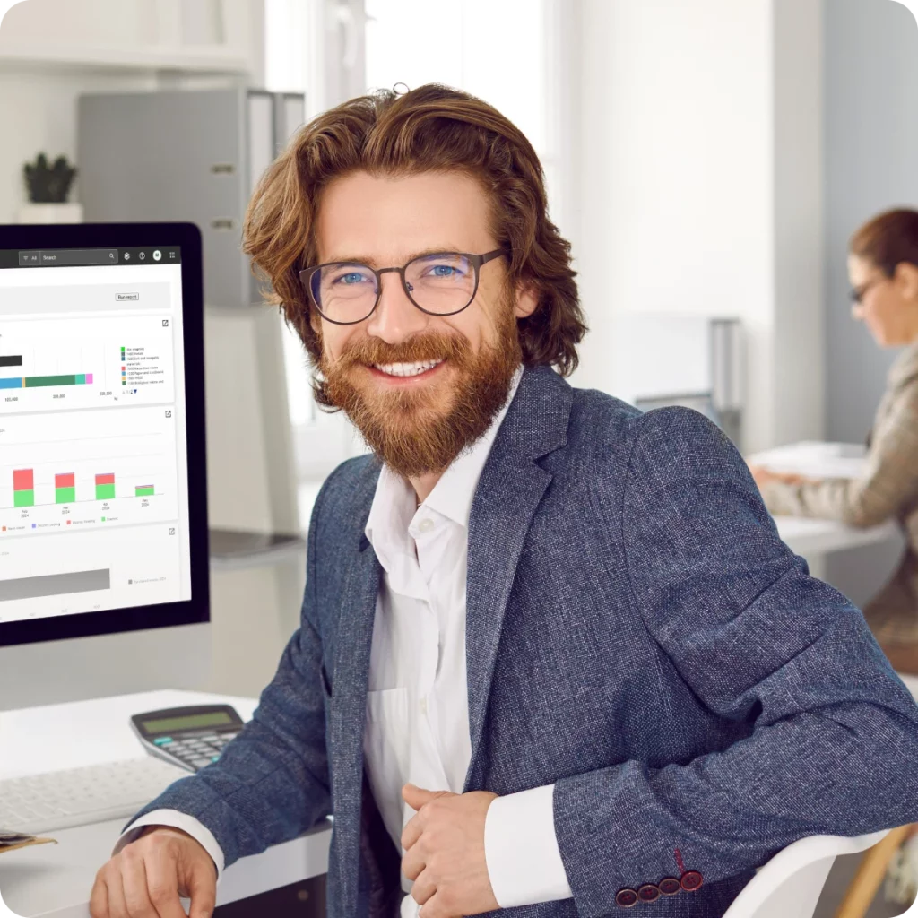 Smilende analytiker som gjennomgår energidata, som representerer viktigheten av rettidig innsikt og proaktiv energistyring.
